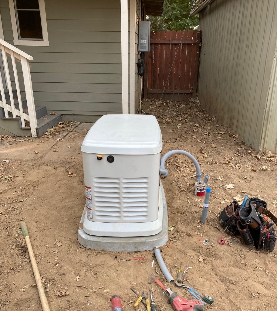 Residential standby generator installation beside a home